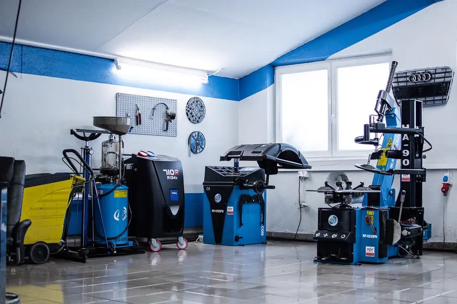 Blaue Reifenmaschinen und Ölwechsel-Geräte aufgereiht in der Werkstatt